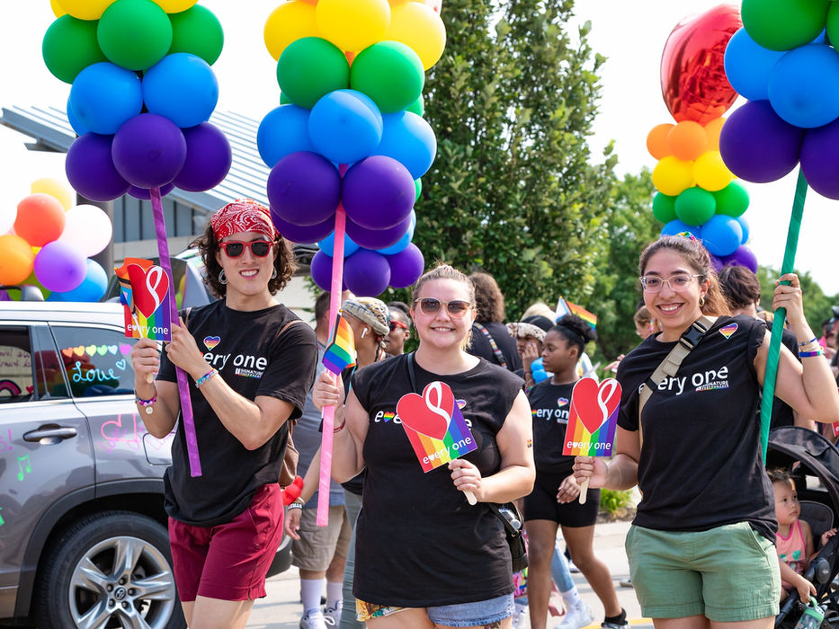 Signature Performance team members at the Heartland Pride Parade with rainbow balloons